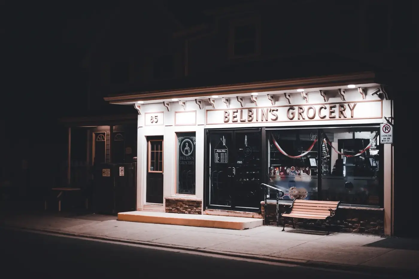 A small independent grocery storefront lit at dusk
